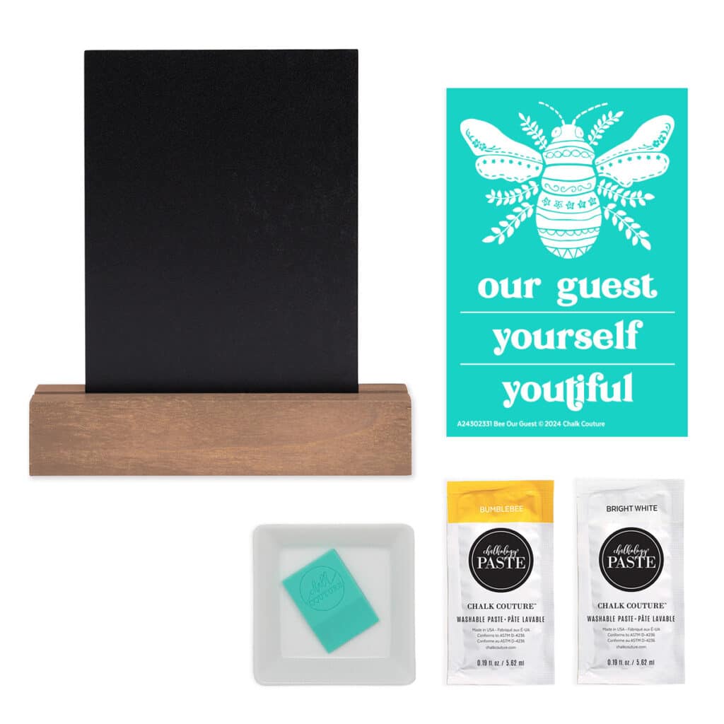 A photo of the contents of the Chalk Couture Bee Our Guest Try Me Kit including the Bee Our Guest stencil, a black board and base surface, a packet of Bumblebee paste, a packet of Bright White paste, a squeegee and color trays for the blog post "Try your hand at chalking with a Chalk Couture Try-me Kit".