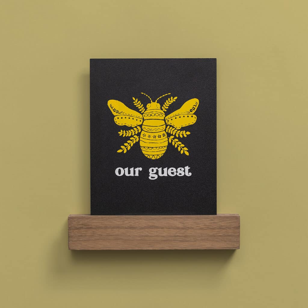 The Chalk Couture Bee Our Guest Try Me Kit with a completed design on a board and base with a yellow bee and the words our guest for the blog post "Try your hand at chalking with a Chalk Couture Try-me Kit".