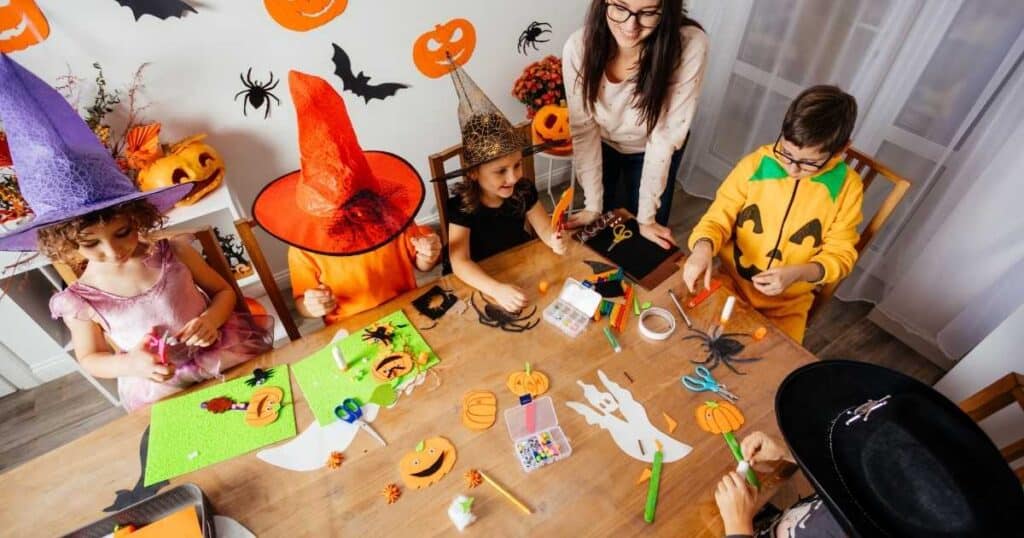 Adjust woman crafting at a table with kids wearing Halloween costumes for blog post 10 Tips for Finding Inspiration for Your Chalk Couture Projects