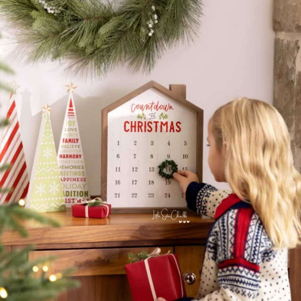 Chalk Couture Advent Calendar in a house frame with a little girl moving a wreath to the next day for blog post Chalk Couture Black Friday Deals