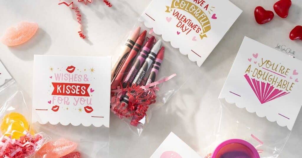 Goody bags holding crayons and candy with words "wishes and kisses for you", "have a colorful Valentine's Day!" and "you're a-dough-able" surrounded by candy lips and hearts for blog post Give the Chalk Couture Winter Collection Some Hugs and Kisses