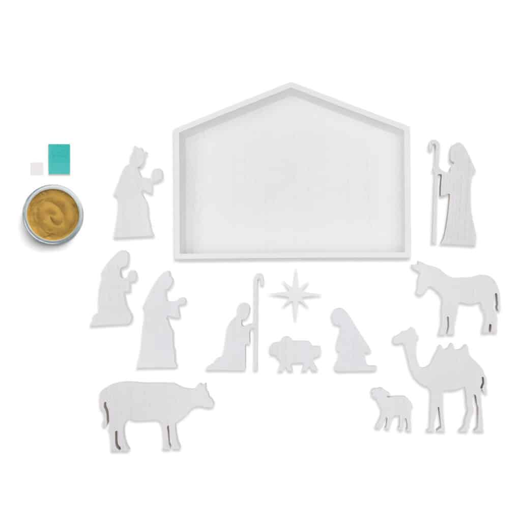 A photo of the ChalkMade Nativity Kit contents including a stable, a star, baby Jesus, Mary, Joseph, a shepherd, the 3 wise men, a donkey, a camel, a sheep and a cow , a jar of Shimmer Gold Chalkology paste, a squeegee, and an adhesive square for the blog post "Class ChalkMade Nativity Kit".