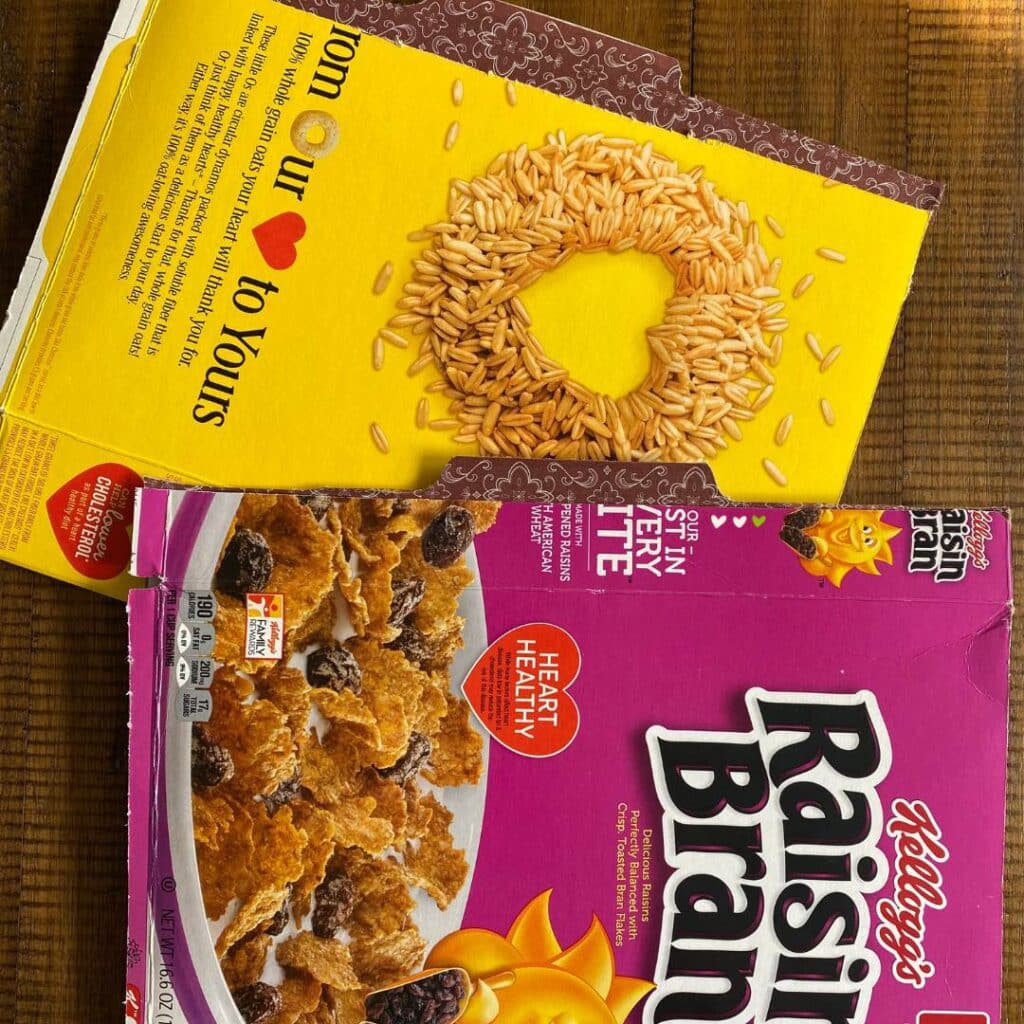 Two file folders made from Raisin Bran and Cheerios cereal boxes on a table for the blog post "Two Simple Ways to Reuse Cardboard Boxes Around Your Home".
