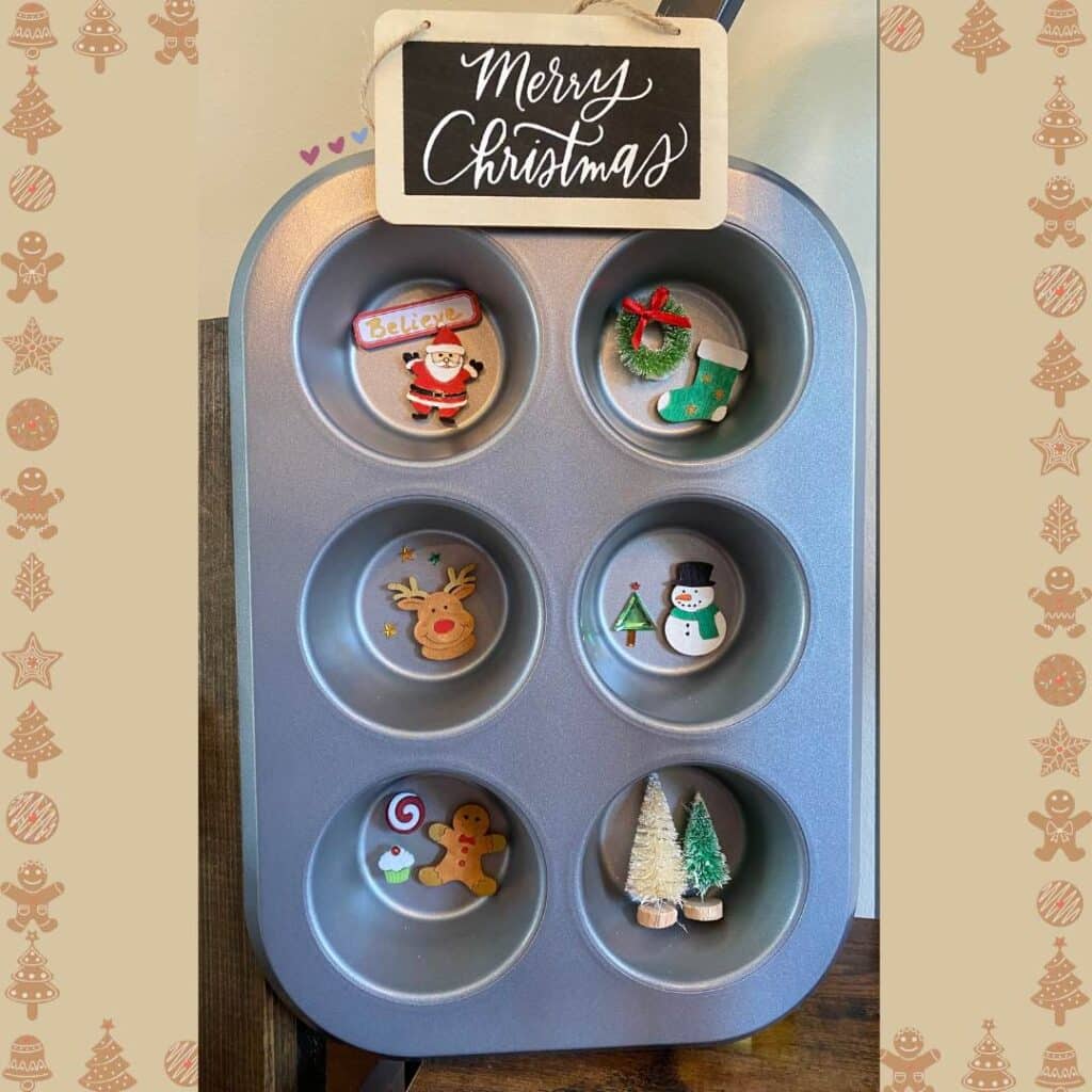 A muffin tin repurposed into a Christmas shadow box with the cups filled with small Christmas embellishments: from top left Santa and the word Believe on a red and white label, a green stocking with a small green wreath with a red bow, Rudolph's head and green and gold stars, a snowman and a Christmas tree, a gingerbread man with red and white candy and a cupcake and two bottle brush trees for the blog post "Simple Baking Pan Crafts You Can Use to Repurpose Your Old Bakeware".