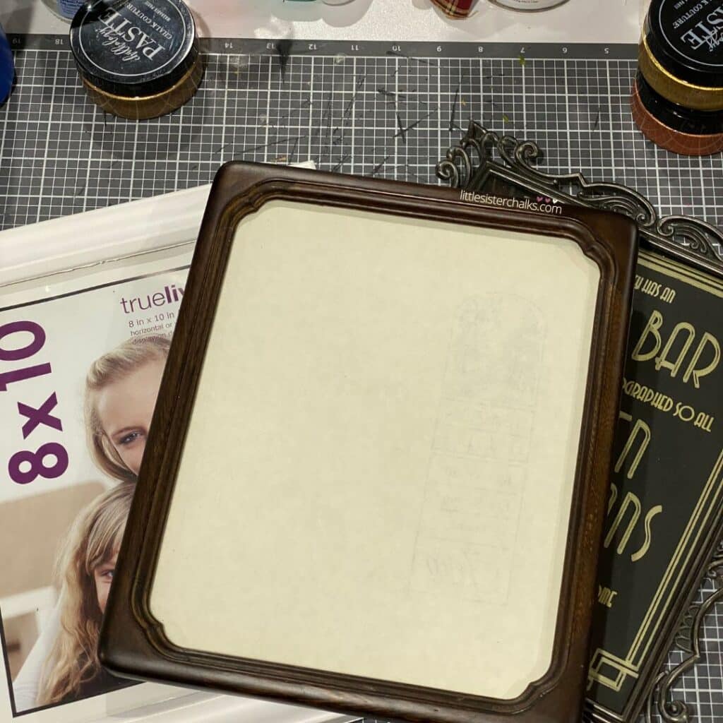 Three picture frames on a craft table for the blog post "Transform Old Picture Frames into Handy Dry Erase Memo Boards".