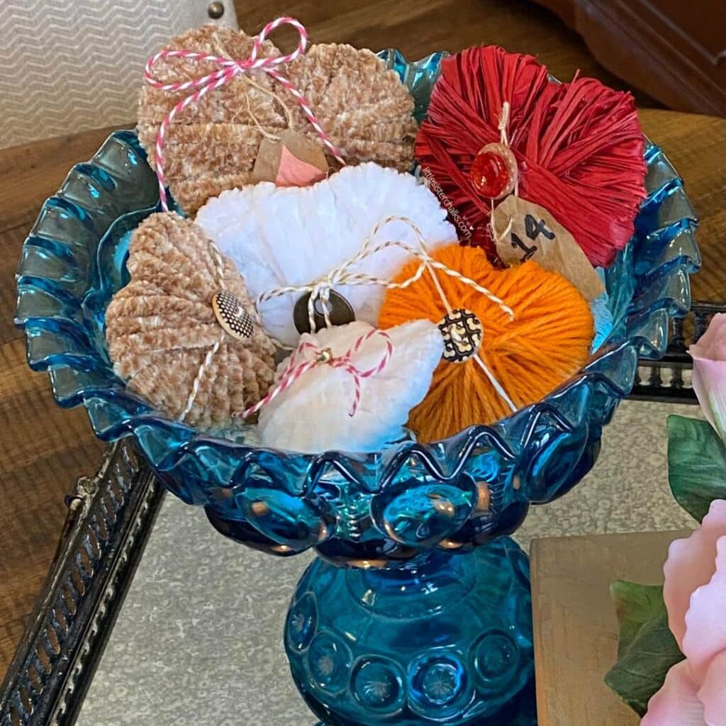 Dimensional hearts in tan, white, orange and red, in a blue bowl on a mirrored tray for the blog post "5 Easy Steps to Create Recycled Cardboard Hearts".