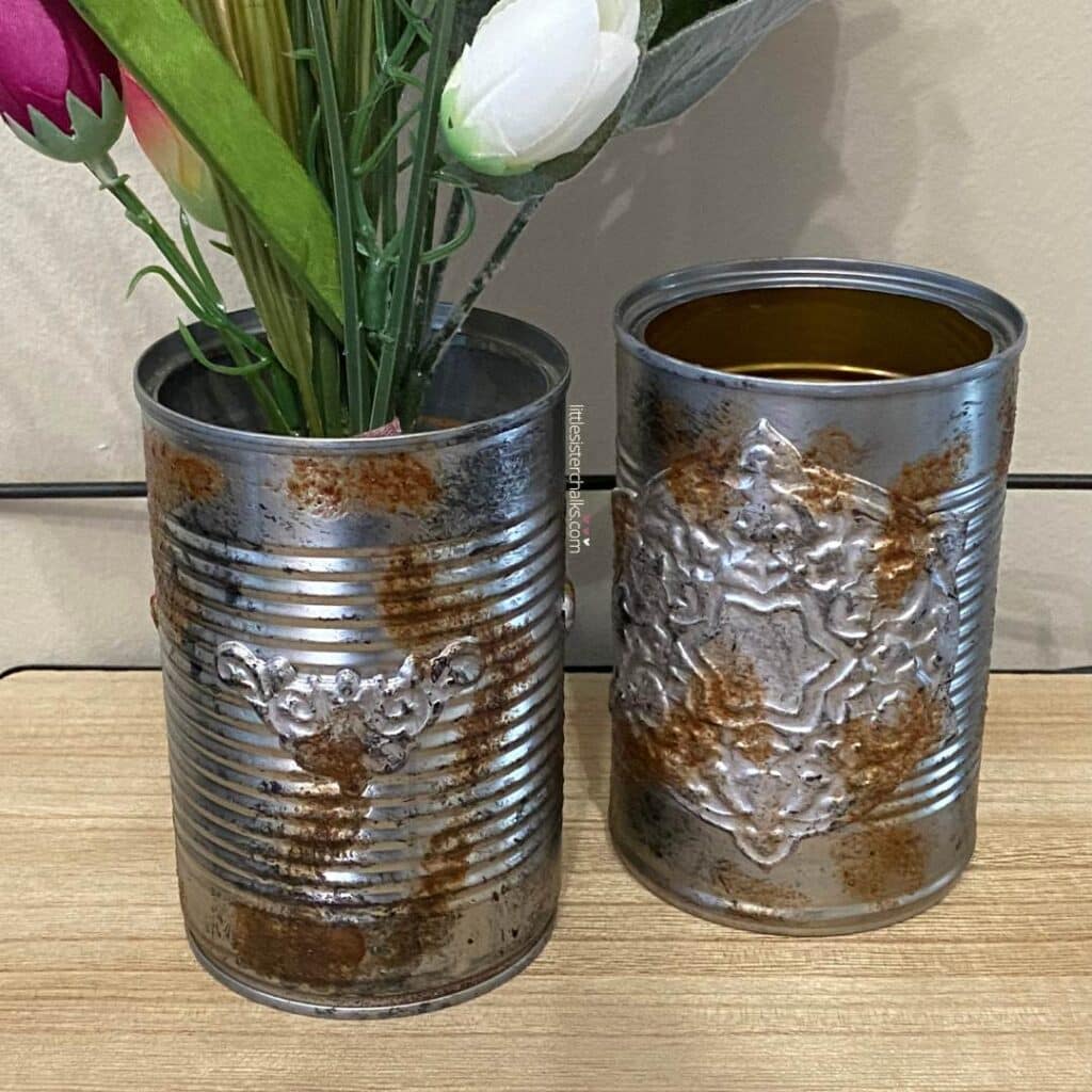A close up of two embellished tin cans for the blog post "Crafting Beyond the Bin: DIY Faux Rusted Tin Cans".